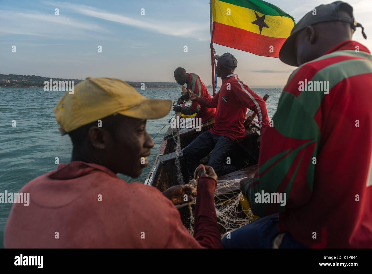 Die Fischer in ihren offenen Boot angeln in den frühen Morgen. Sie Schaufel von Netz zu Netz Ihre verfangen, Kokrobite, Greater Accra Region, Ghana zu holen Stockfoto
