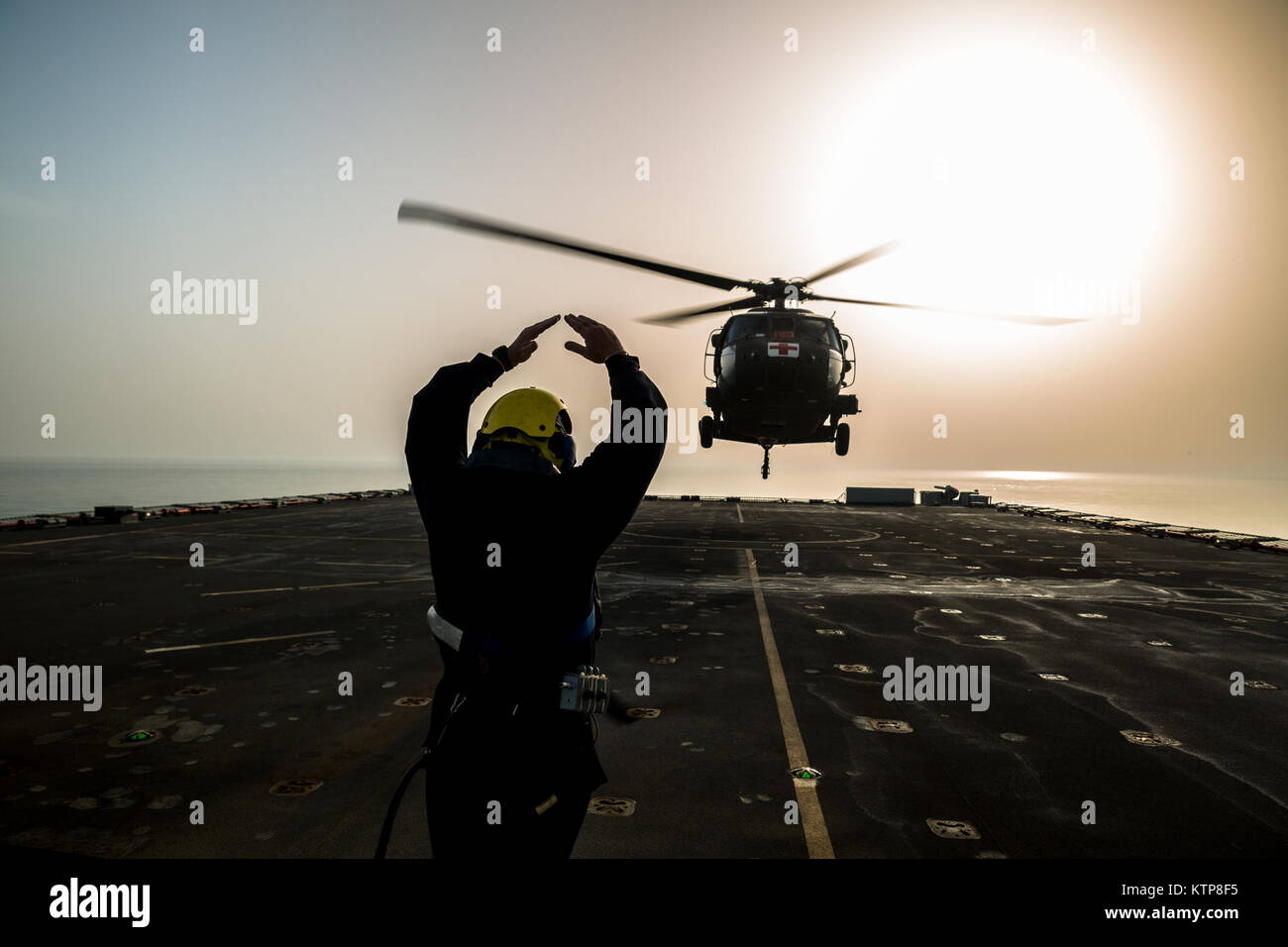 Petty Officer Ian Walker, ein Deck Hand auf die RFA Cardigan Bay, Royal Fleet Auxiliary, britische königliche Marine, gibt das Signal zum abheben, ein UH-60 medizinische Evakuierung Black Hawk von Piloten geflogen vom 1. Bataillon, 214th Air Ambulance, 42. Combat Aviation Brigade (CAB), US-Armee am 8. Juni 2014, irgendwo in den Persischen Golf.  Die Piloten ausgebildet auf Deck Landungen während Übung Spartan Kopis, einen Austausch zwischen der Cardigan Bay und die Black Hawk und AH-64 Apache Elemente der 42. Kabine, New York Army National Guard.    Spartan Kopis war das erste Mal, mit denen amerikanische Apachen eine königliche gearbeitet Stockfoto