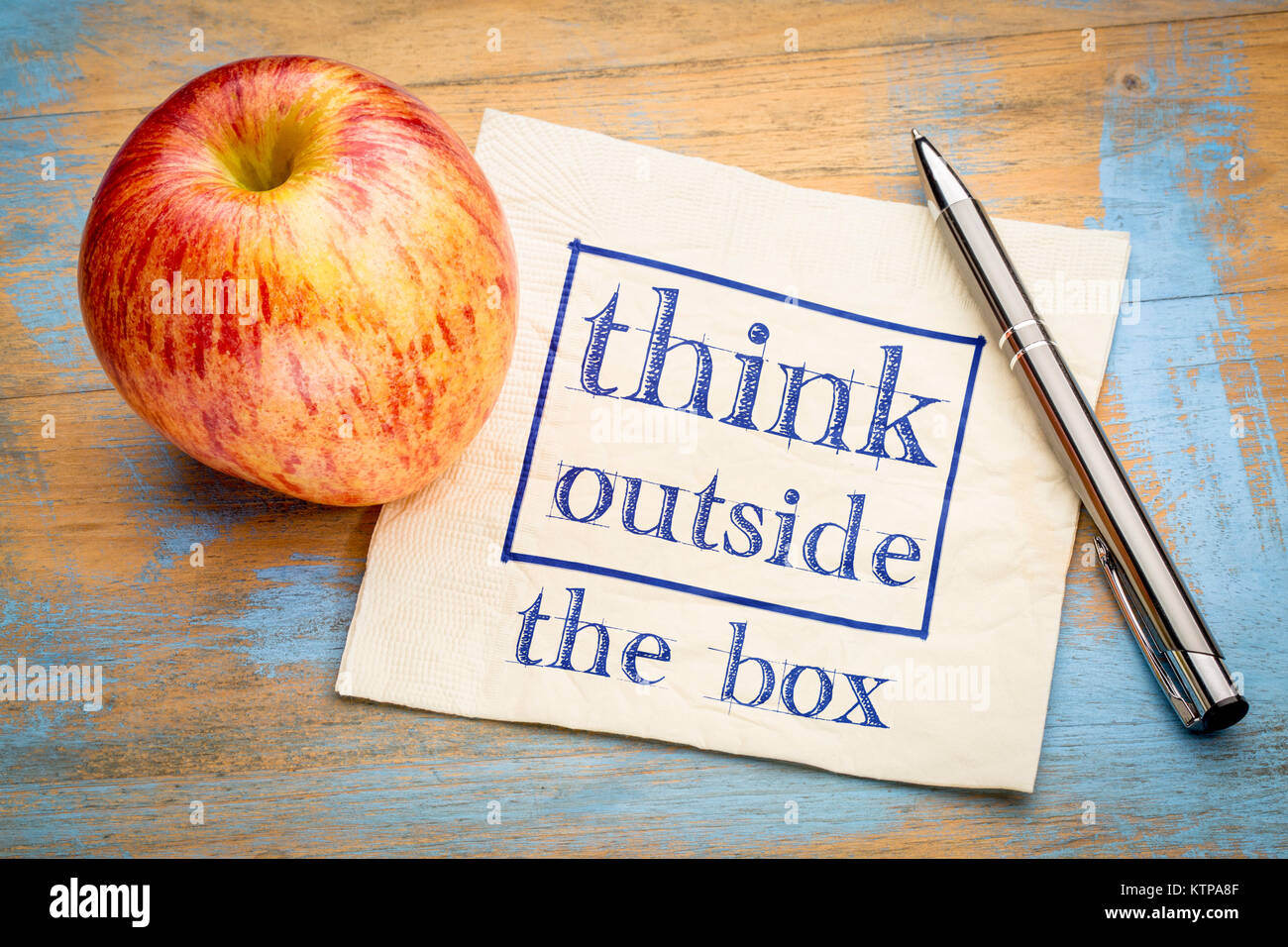 Denken außerhalb der Box Konzept - Handschrift auf eine Serviette mit einem Apple Stockfoto