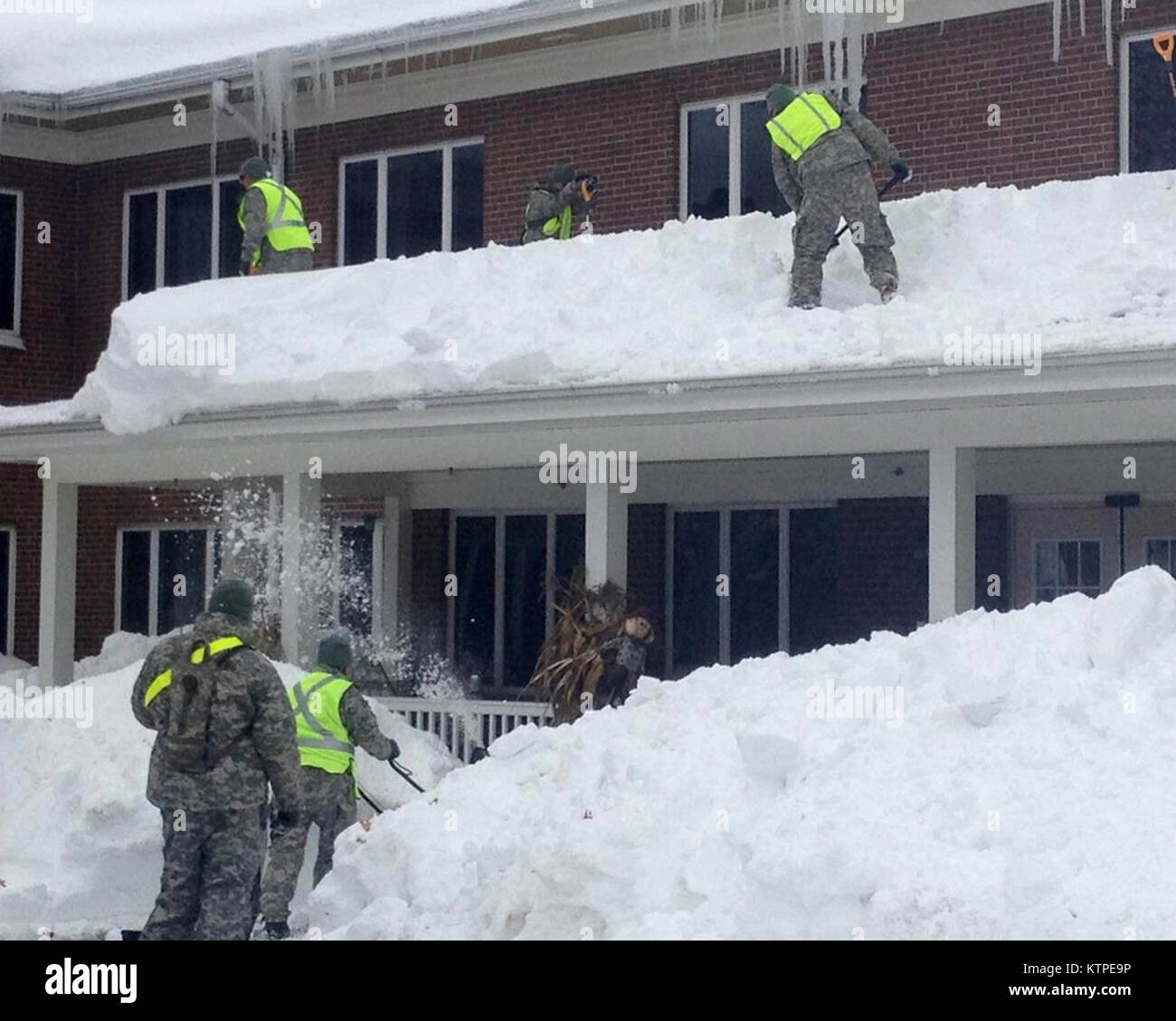 New York Army National Guard Soldaten von Unternehmen ein, die Unterstützung der Feuerwehr 427th Battalion, Hauptsitz in Rochester, helfen bei der Schneeräumung vom Dach der Absolut Pflege betreutes Wohnen Senior Care Center in Orchard Park, New York November 22. Die 42 Soldaten, die von Kapitän David Myones aus South Ozone Park, New York geboten hatte, wurden von einem weiteren Dutzend freiwillige Mitglieder der New York Schutz Staat Defence Force, die von Gouverneur Andrew M. Cuomo mit Recovery in Western New York folgenden historischen Mengen Schneefall in dieser Woche zu helfen. Myones' Firma hat auch Soldaten durchführen Stockfoto