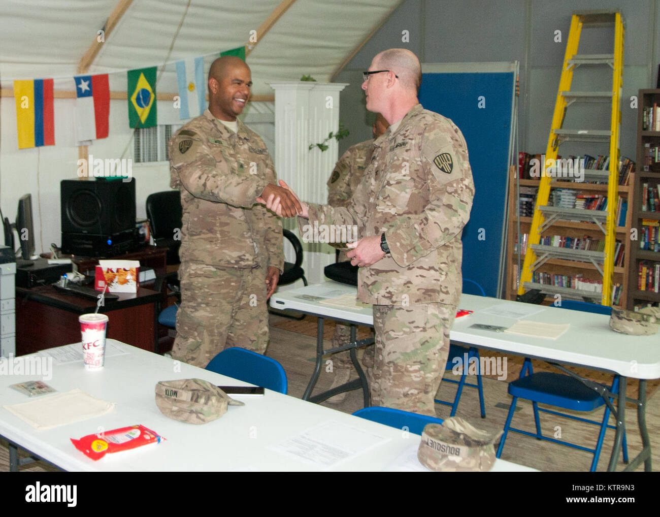 Oberst Stephen Bousquet, der Kommandant der 369. sustainment Brigade, präsentiert eine Brigade Münze zu Sgt. Yovani Mota, der HHC 369 th, für seine herausragenden Leistungen bei der Durchführung von Klassen in den ordnungsgemäßen Gebrauch, die Pflege und Prüfung von Feld Schutzmasken im Camp Arifjan, Kuwait, am 4. Februar 2017. (U.S. Armee Foto von Sgt. Jeremy Bratt) Stockfoto