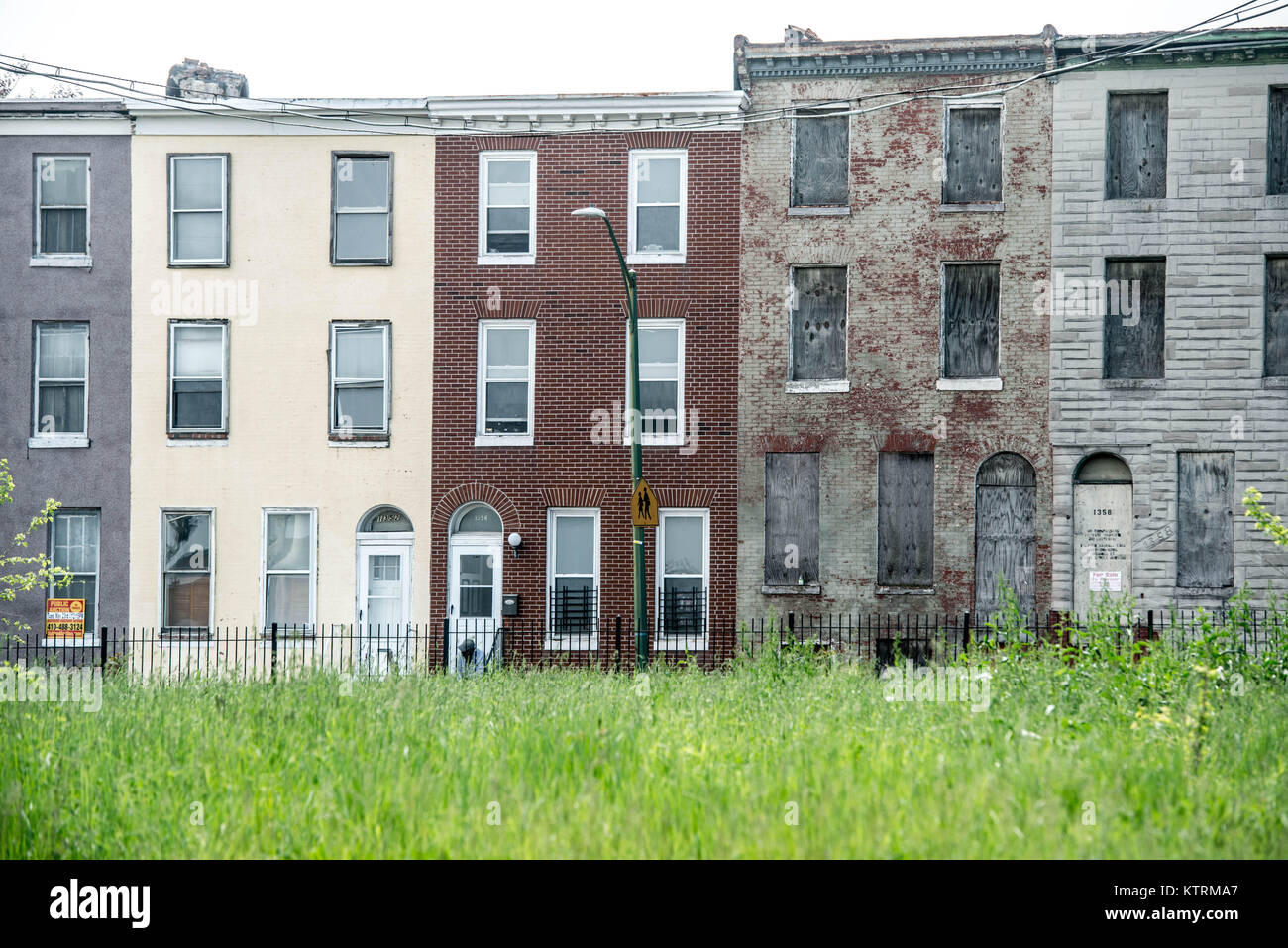 Zwei Zeile Wohnungen sitzen frei Neben bewohnt, die an der Pennsylvania Avenue in Baltimore City, MD Stockfoto