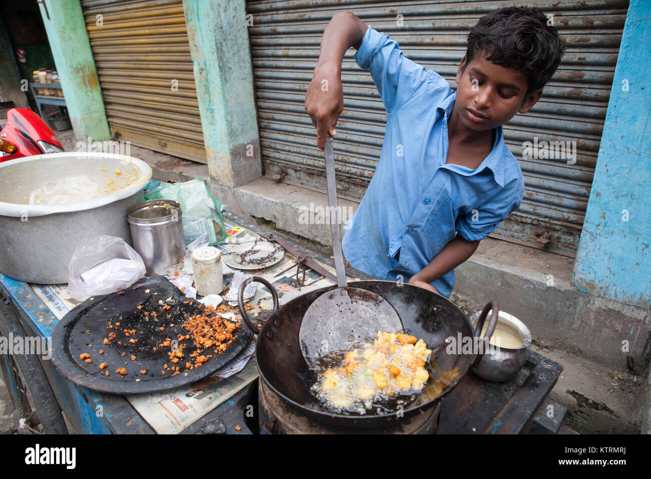 Ein Junge Pommes chili pakora am Markt Asansol, Indien Stockfoto