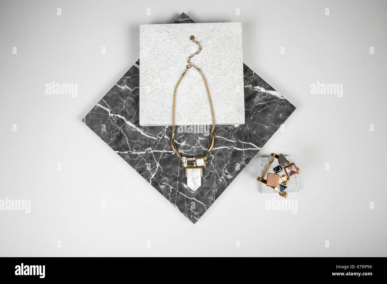 Goldene Halskette Kette und Armband auf quadratischen schwarzen Stein Stockfoto