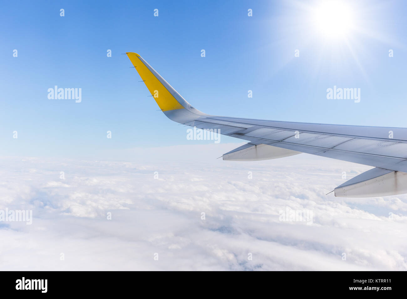Flugzeugflügel auf Flug über den Wolken mit sonnigen blauen Himmel. Stockfoto