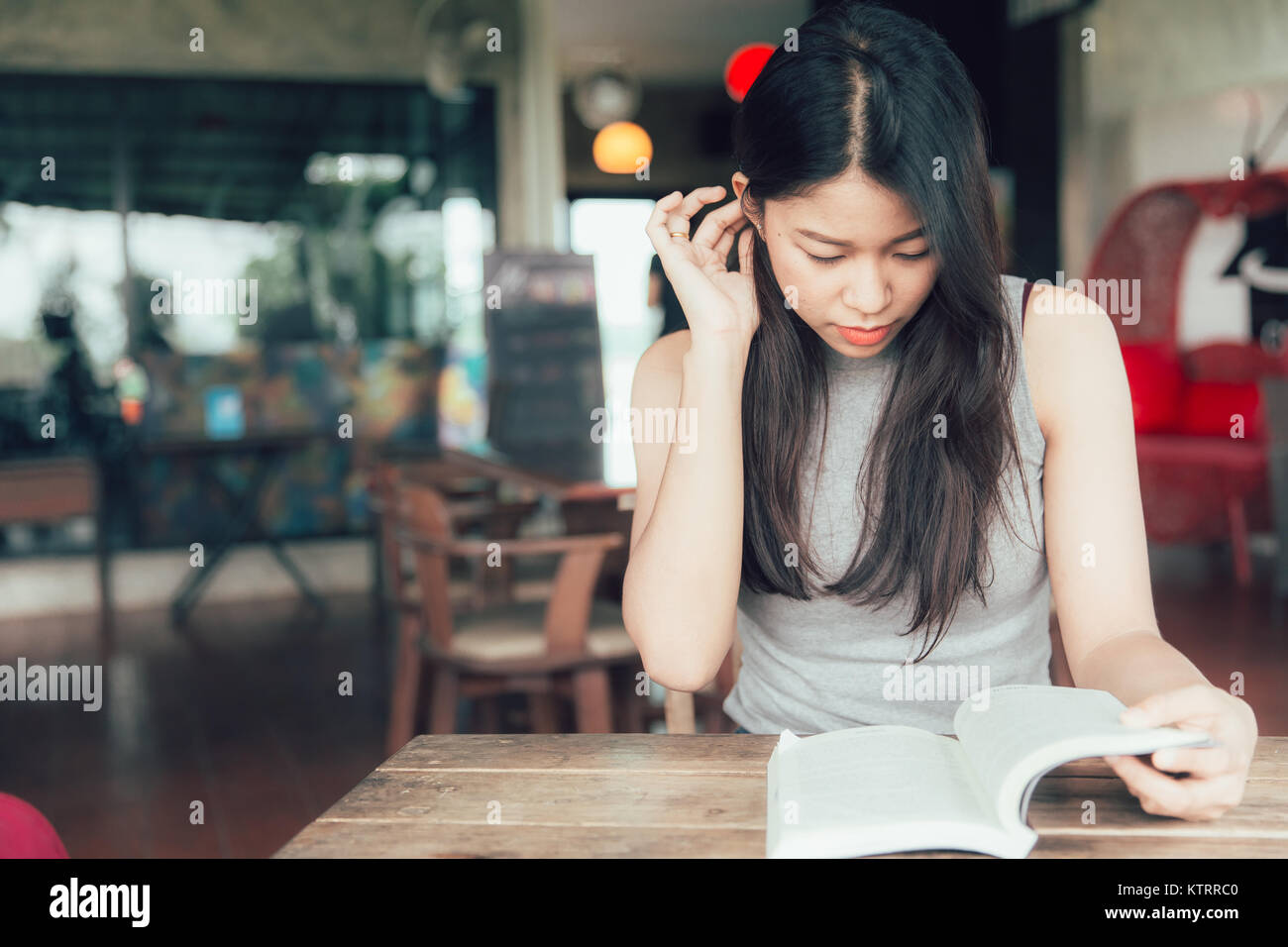 Genießen Sie Zeit mit Lesen von Büchern asiatische Frauen schöne Thai jugendlich ein Buch in Coffee Shop vintage Farbe Ton lesen entspannen Stockfoto