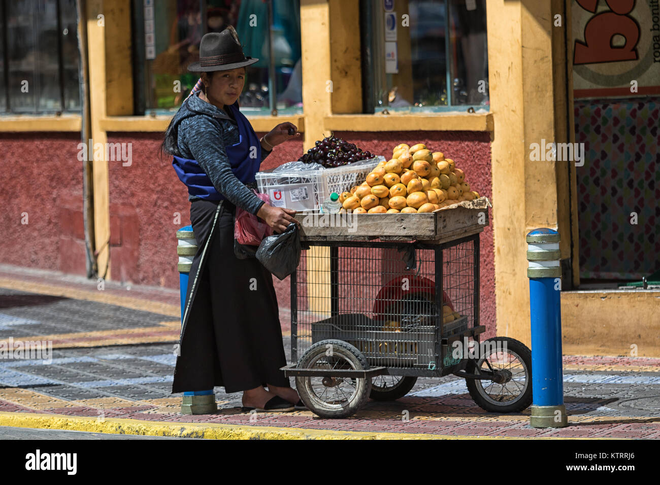 Otavalo, Ecuador-December 23, 2017: indigene Frau verkaufen Obst om die Straße n Das beliebte touristische Stadt Stockfoto