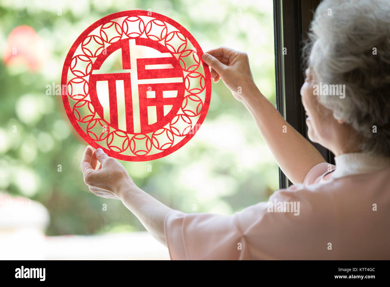 Ältere Frau mit Chinese New Year Scherenschnitt Stockfoto