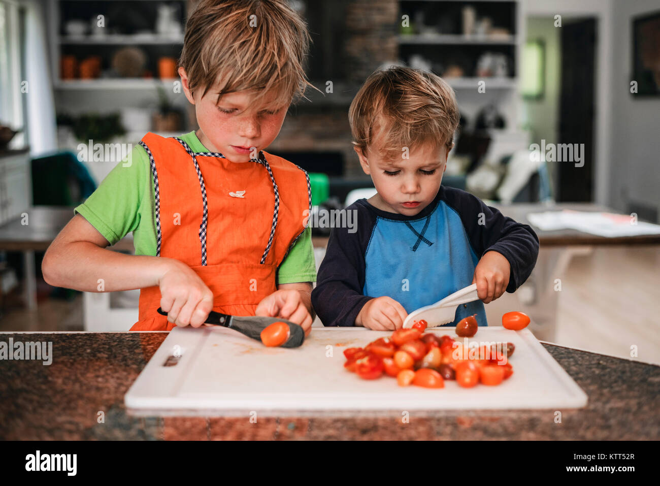 Zwei Jungen hacken Tomaten in der Küche Stockfoto