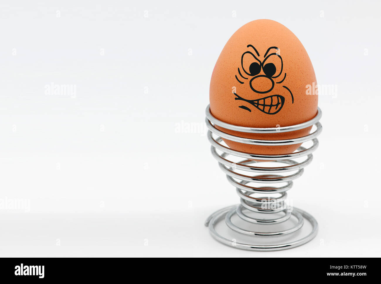 Ein Ei in einem Eierbecher mit einem wütenden Gesicht Stockfoto