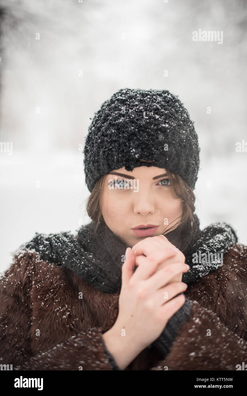 Porträt eines lächelnden Frau, die in den Park an einem verschneiten Tag Stockfoto