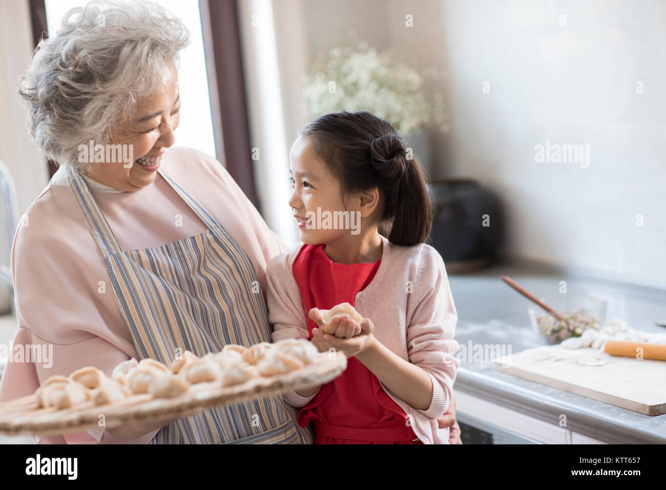 Fröhlichen Enkelin und Oma Knödel in der Küche Stockfoto