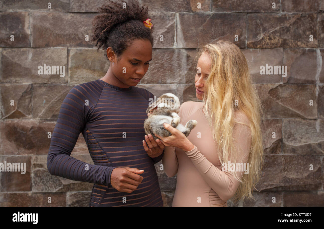 Mixed Race Paar junges Mädchen zusammen mit Bunny Kaninchen in Händen Stockfoto
