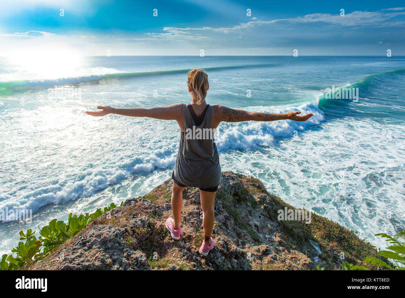 Schöne Passform Surfer Girl Paddeln in das kristallklare Wasser des Indischen Ozeans bei Uluwatu Strand, Bali, Indonesien. Platz kopieren Stockfoto