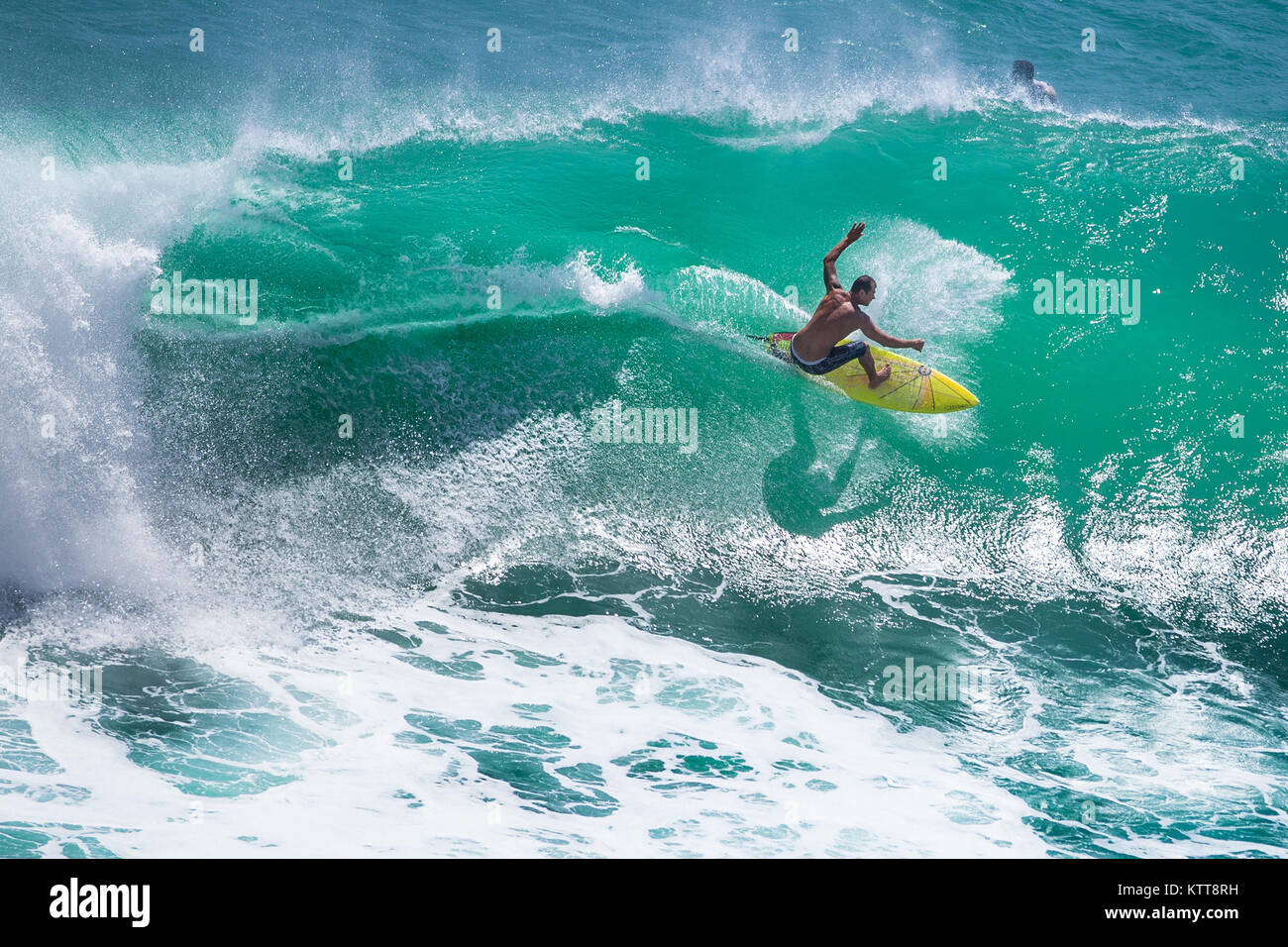 Surfer reiten große grüne Welle in Padang Padang Strand, Bali, Indonesien Stockfoto