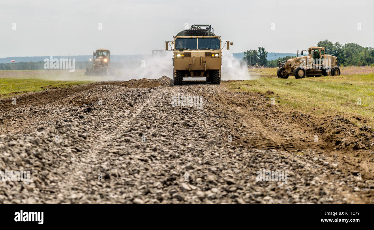 New York Army National Guard Soldaten mit der 827Th Engineer Company, 204 Techniker Bataillon, Zerreißen und das eine Probefahrt während ihrer jährlichen Training in Fort Drum, N.Y., 19. Juli 2017. Die Straße ist eine von vier Bauvorhaben das Bataillon während seiner Zeit in Fort Drum, der den Soldaten ihre Fähigkeiten zu verbessern, während die Schaffung dauerhafter Bau Projekte für die Post lief. (U. S. Army National Guard Foto von Sgt. Harley Jelis) Stockfoto