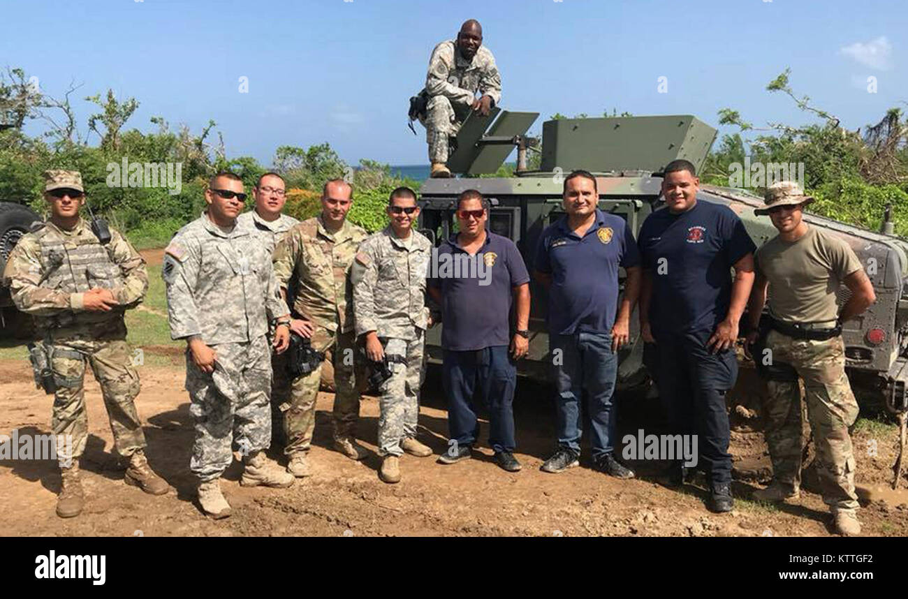 Soldaten zugeordnet 442Nd militärischen der New York Army National Guard Polizei Unternehmen eine pipcture mit Mitgliedern des Viques, Puerto Rico Feuerwehr, der ihnen half, militärische Fahrzeuge im Schlamm stecken wiederherstellen. Die Soldaten waren die Durchführung einer Sicherheit Mission auf der Insel. Soldaten in die 442Nd Militärpolizei Firma zugewiesen eingesetzt nach Puerto Rico für Sicherheit sorgen und in Hilfsaktionen unterstützen nach dem Hurrikan Maria. Stockfoto