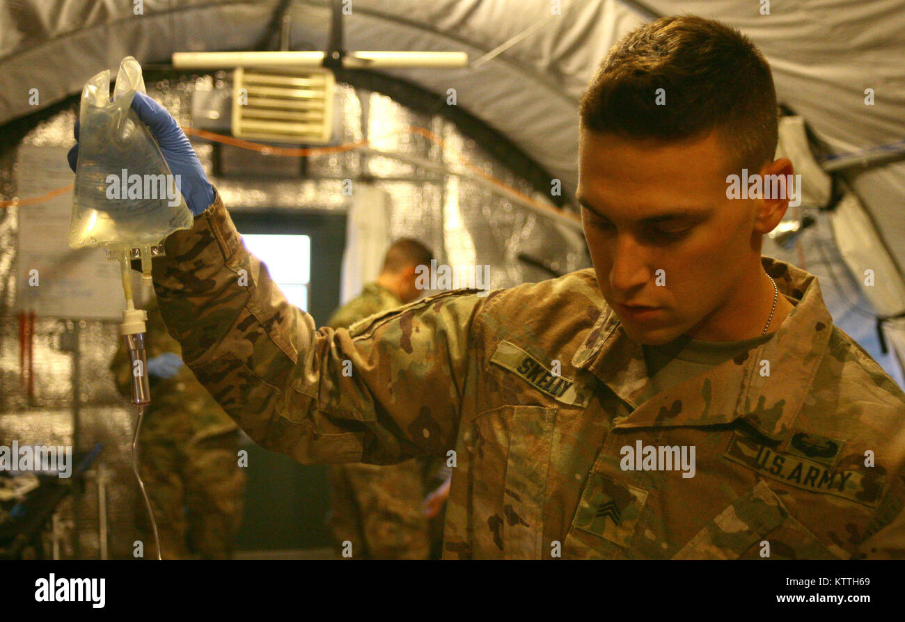 Yavoriv, Ukraine - Sgt. Joseph Skelly, combat Medic zugewiesen, die der Gemeinsamen multinationalen Ausbildung Group-Ukraine übt ein IV-Katheter mit einem Patienten während einer massiven Unfall (mascal) Übung am Yavoriv Combat Training Center Nov. 17. Während der Übung der Einheit Ärzte auf ihre Fähigkeiten und Techniken getestet wurden, während in der Triage, zu behandeln, und den Transport einer großen Anzahl von simulierten Patienten. (U.S. Armee Foto von Sgt. Alexander Rektor) Stockfoto