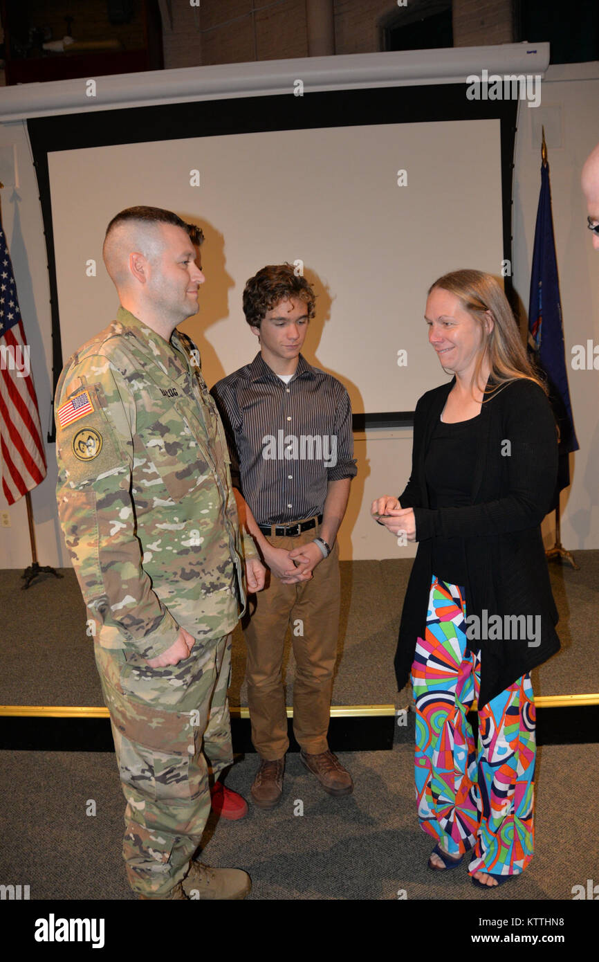 New York Army National Guard Soldat Oberstleutnant Todd Balog (links), der Kommandant der speziellen Truppen Bataillon, erhält von Oberst Stephen M. Bousquet, der Kommandant der 369. sustainment Brigade gefördert, und seiner Familie in seiner Promotion Zeremonie im Staat New York Military Museum in Saratoga Springs, New York, 8. Dezember 2017. Balog ist ein Afghanistan Veteran und Bewohner von Saratoga Springs, New York (USA Army National Guard Foto vom Kapitän Jean Marie Kratzer) Stockfoto