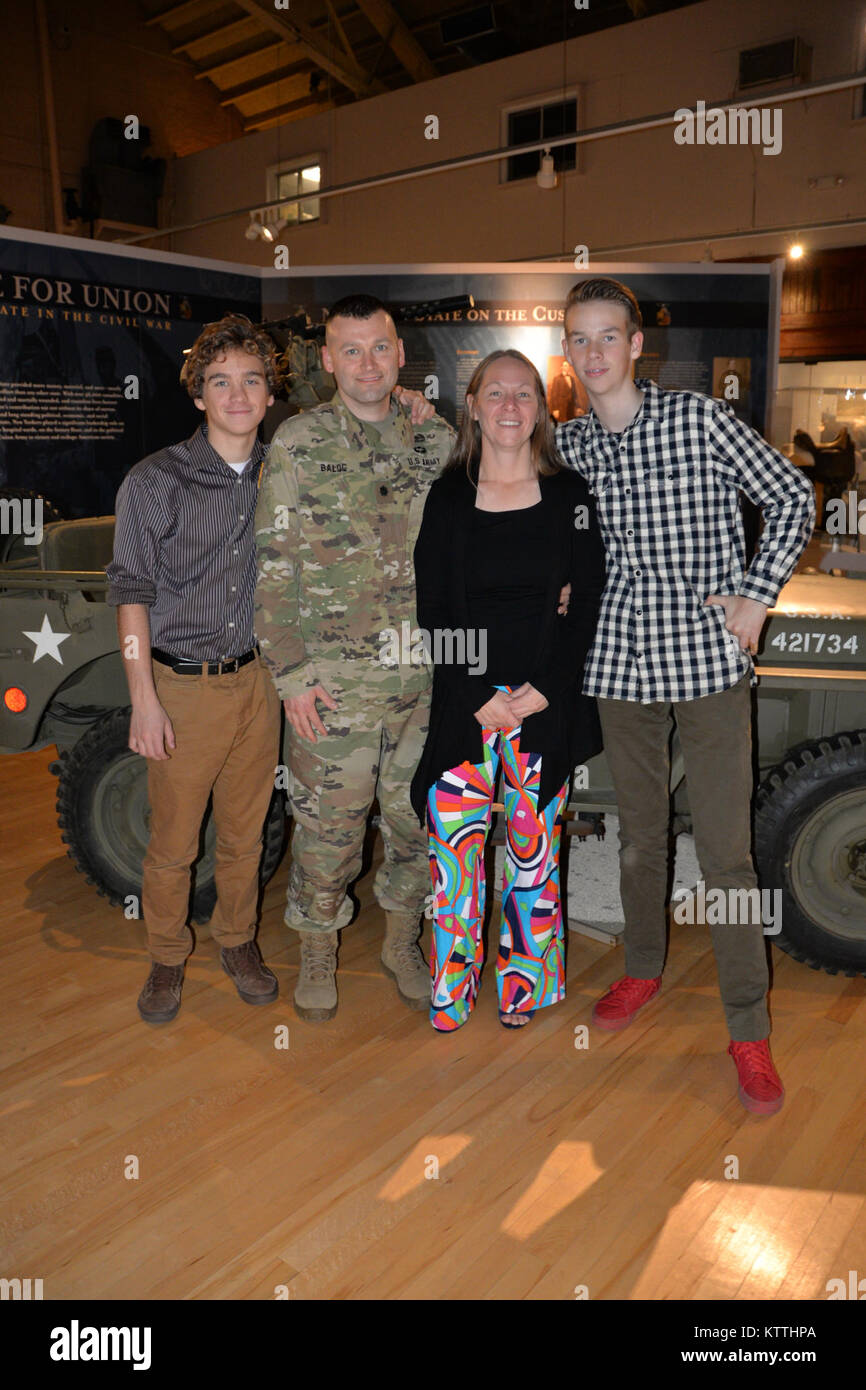 New York Army National Guard Soldat Oberstleutnant Todd Balog (links), der Kommandant der speziellen Truppen Bataillon, wirft mit seiner Familie nach seiner Promotion Zeremonie im Staat New York Military Museum in Saratoga Springs, New York, 8. Dezember 2017. Balog ist ein Afghanistan Veteran und Bewohner von Saratoga Springs, New York (USA Army National Guard Foto vom Kapitän Jean Marie Kratzer) Stockfoto
