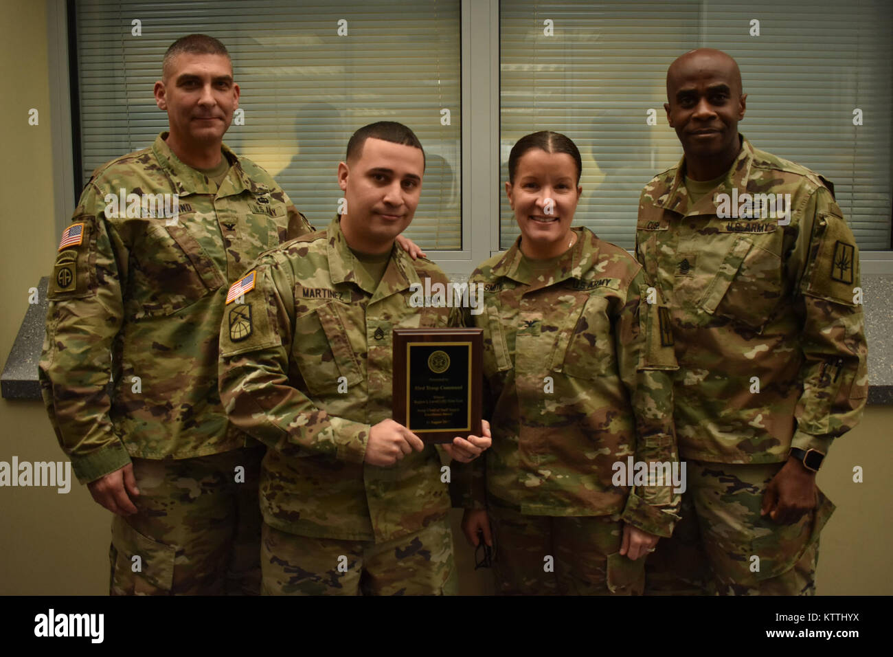 New York Army National Guard Soldat, Staff Sgt. Danny Martinez, Supply Sgt. HHD, 53 Truppe den Befehl, steht mit Oberst Carlton Cleveland (ganz links), Oberst Isabel Smith (Mitte rechts) und Sgt. Maj. Corey Kusch (ganz rechts) während der New Yorker Nationalgarde gemeinsame Kommandeure, Latham, N.Y., Dez. 9, 2017. Martinez erhielt die regionale Versorgung Wettbewerb Exzellenzinitiative Plakette und drei Münzen. (N.Y. Army National Guard Foto von SPC. Andrew Valenza) Stockfoto