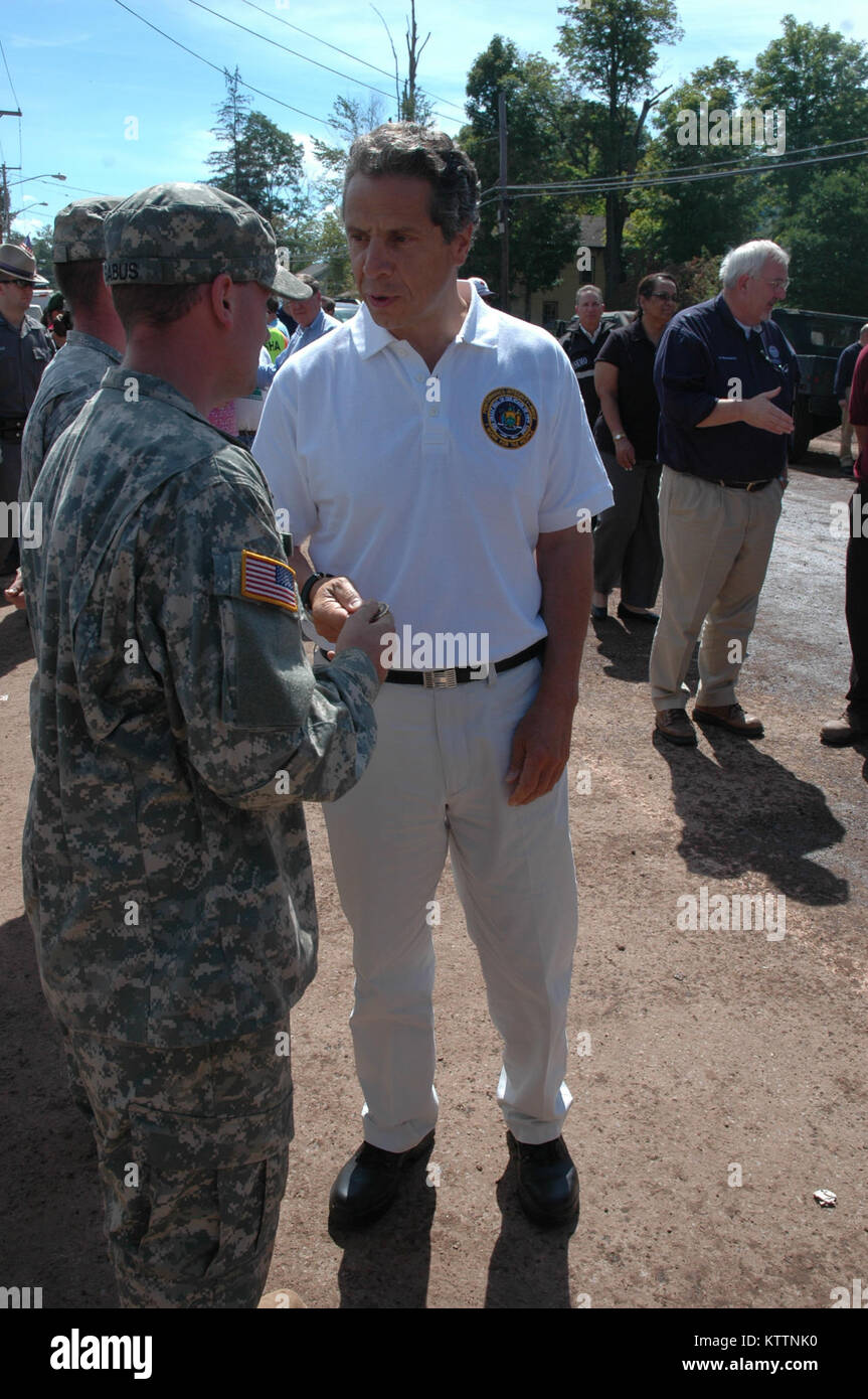 Pratsville, NY - reg. Andrew Cuomo, Commander-in-chief des New York National Guard stellt die Gouverneure Münze zu Spc. Whitnee Mckinney für ihre herausragende Unterstützung in Reaktion auf den Hurrikan Irene, wie die NY Adjutant General Generalmajor Patrick Murphy schaut, hier, 12.08.31. Stockfoto