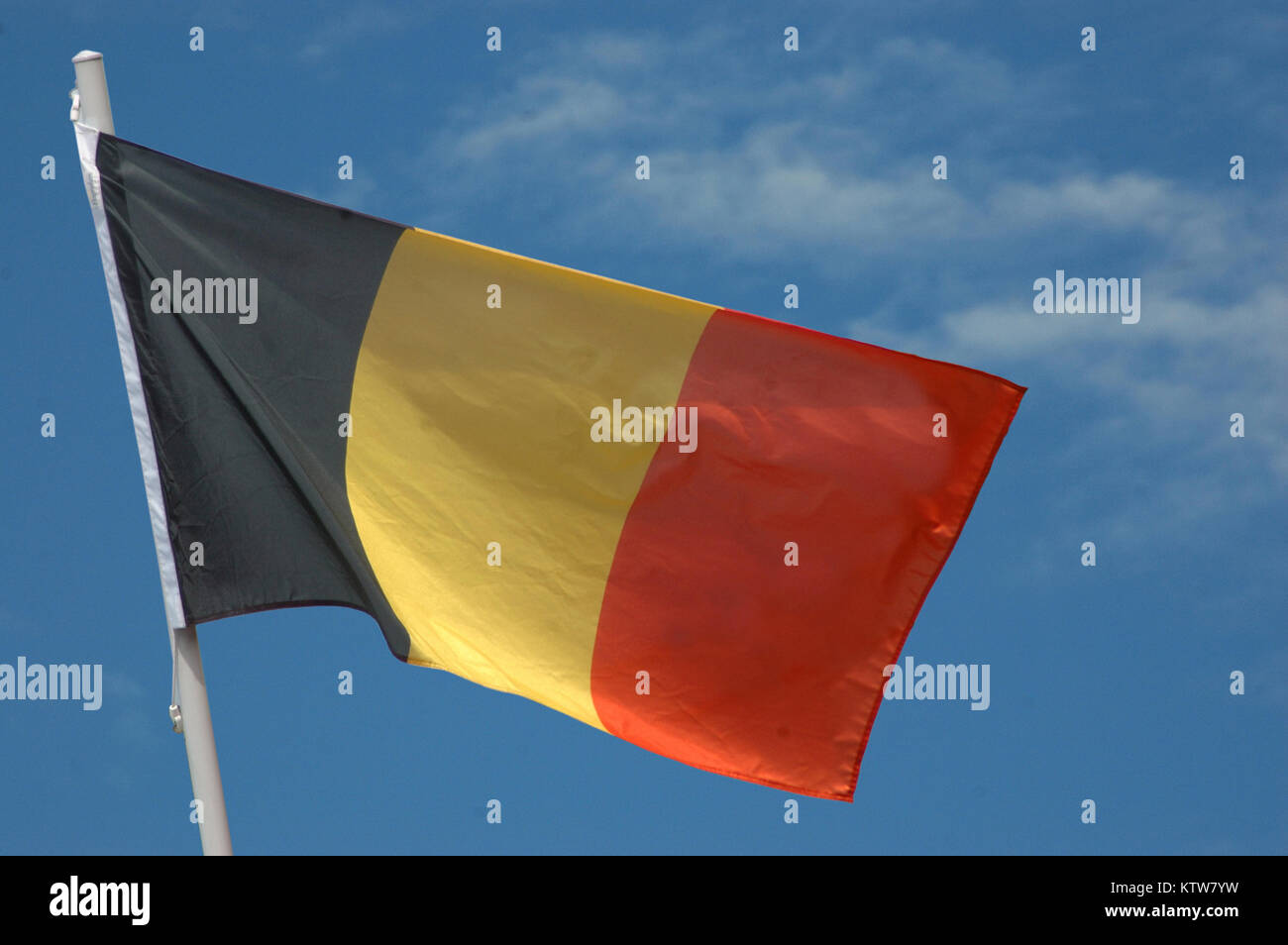Belgische Flagge gegen den blauen Himmel Stockfoto