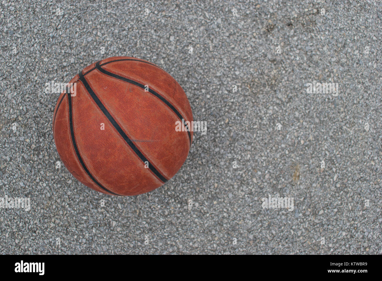 Verwendet orange Leder Basketball auf grauem Asphalt Hintergrund. Stockfoto