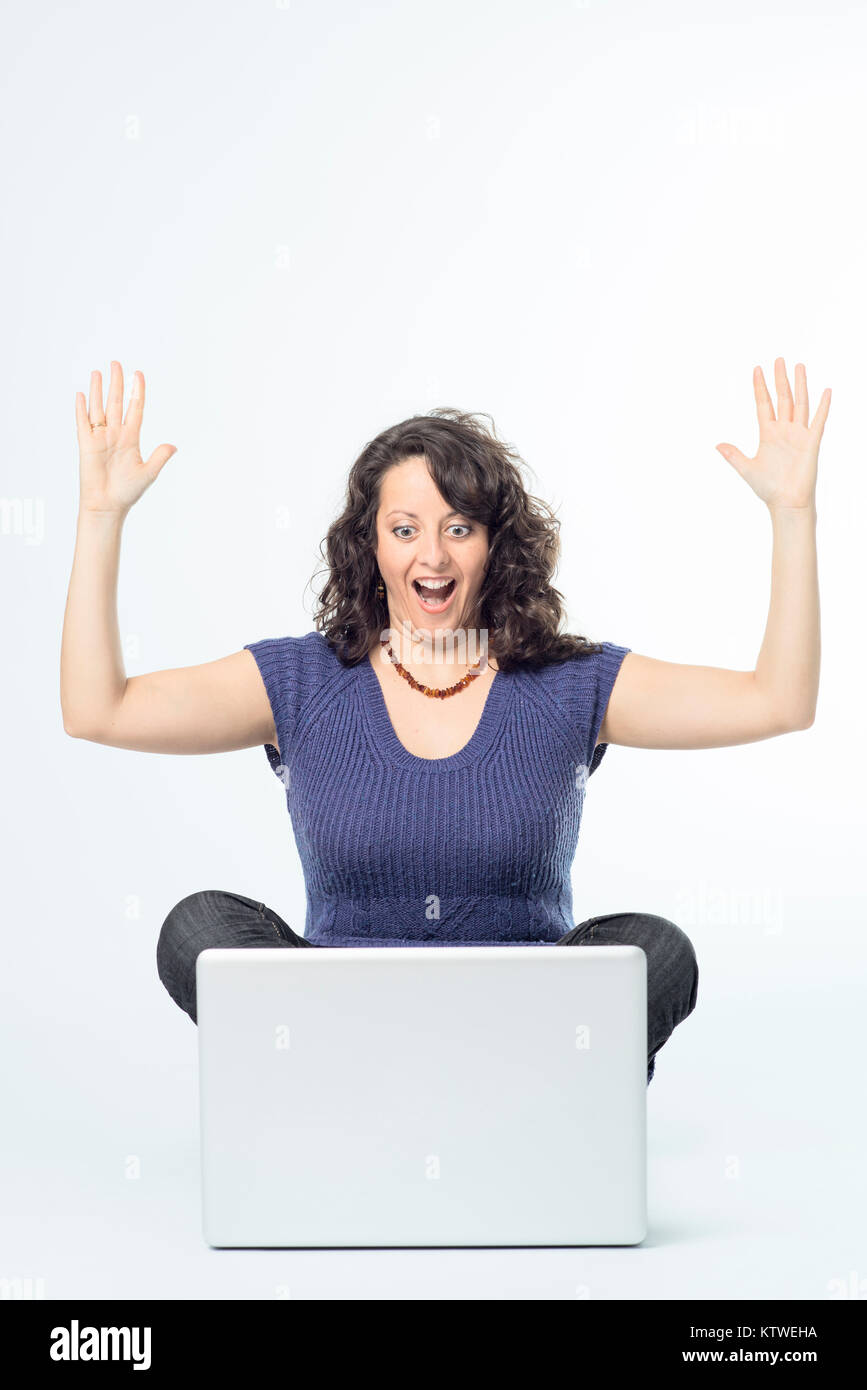 Farbe Fotografie der jungen Frau mit Überraschung Ausdruck vor Laptop Stockfoto
