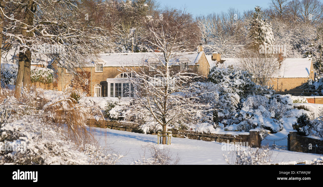Bourton auf dem Hügel Haus im Schnee bei Sonnenaufgang im Dezember. Bourton auf dem Hügel, Cotswolds, Gloucestershire, England. Panoramablick Stockfoto