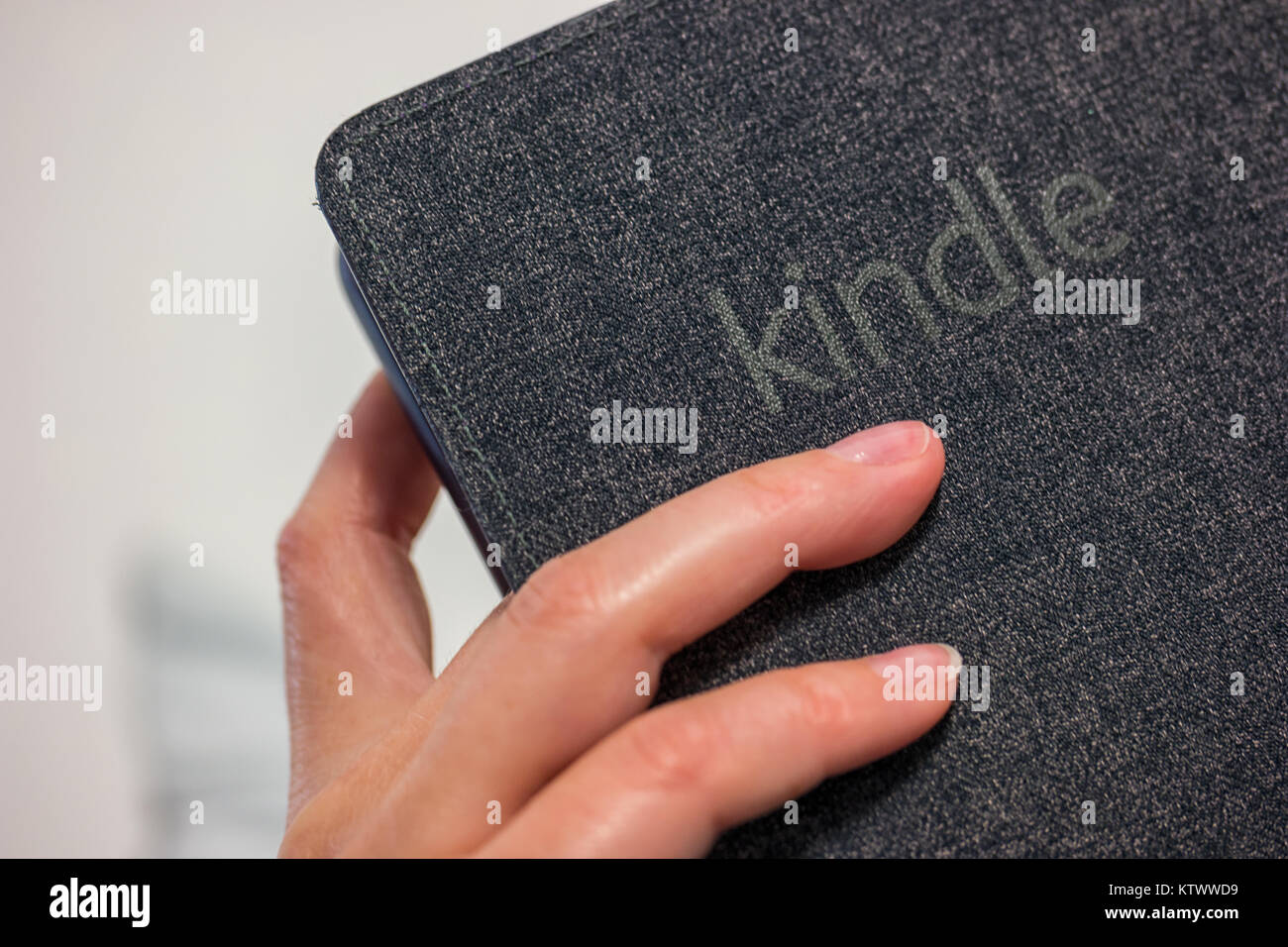 Frau Hand e-book reader (Amazon Kindle Paperwhite) in seiner Hand. Eine der am meisten Pappel Lesegeräte für ebooks. Stockfoto