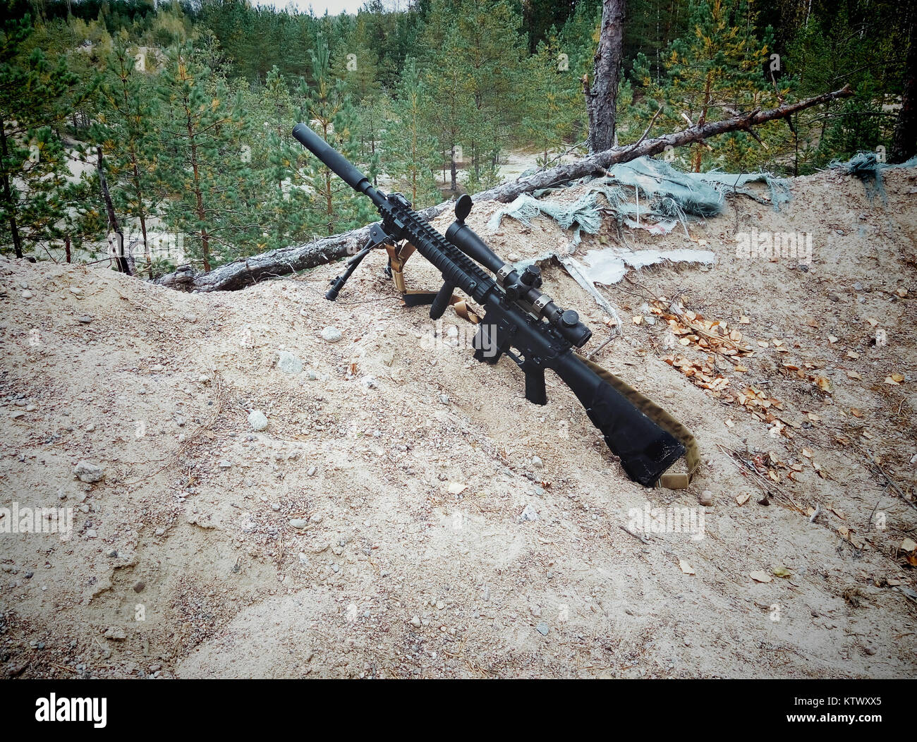 Sturmgewehr auf dem Hintergrund der Pinienwälder und Sand. Stockfoto