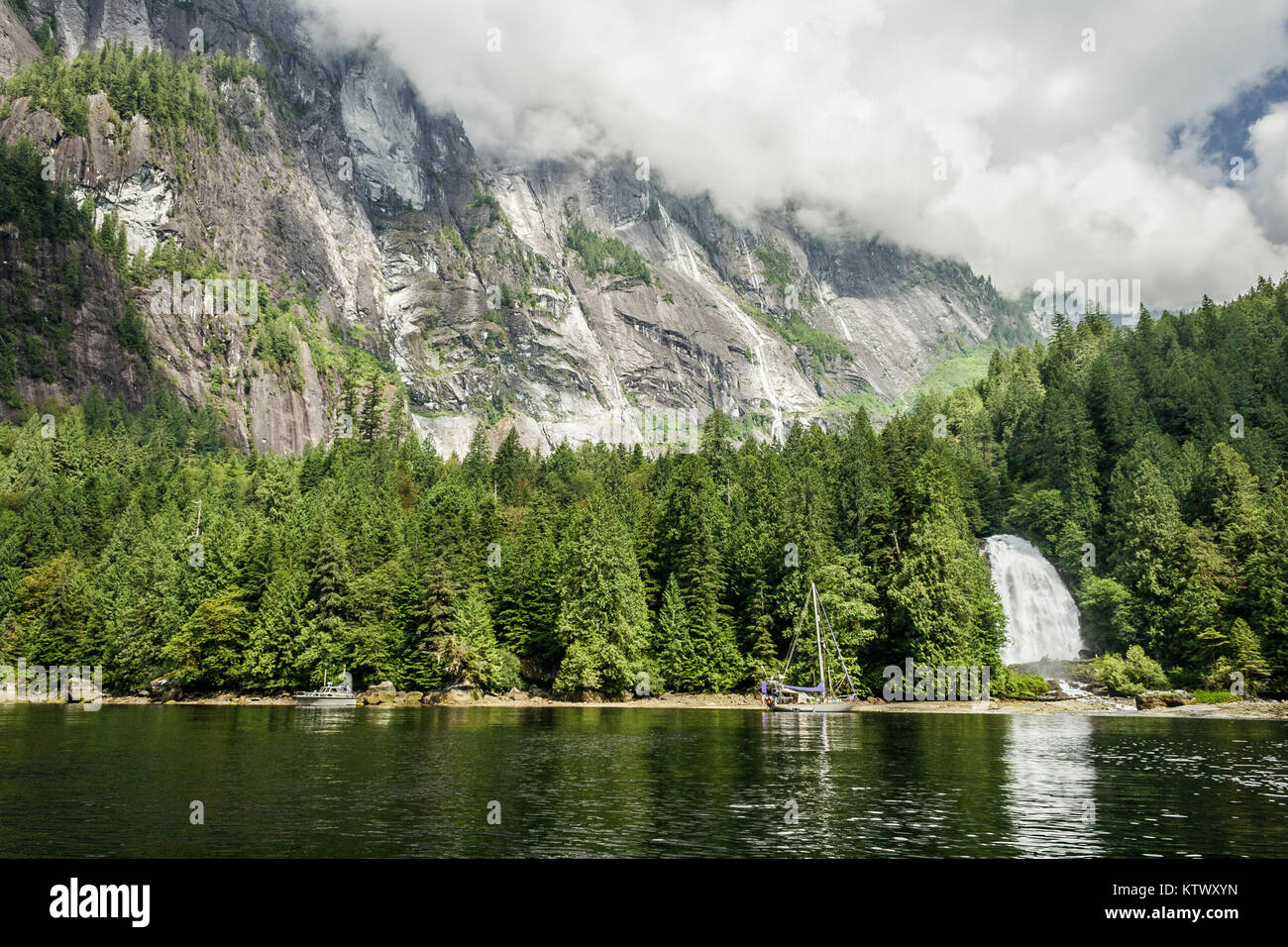 Während Wolken verdecken die Oberseiten der steilen Spitzen über, zwei Boote in der Nähe von Chatterbox fällt in Princess Louisa Inlet, British Columbia verankert sind. Stockfoto