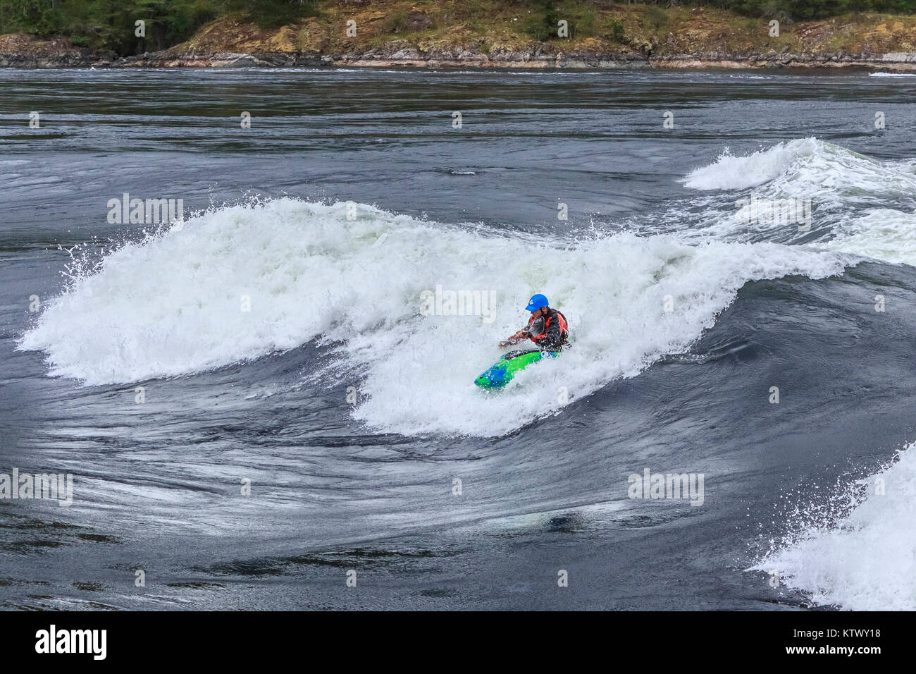 Als das Wasser um ihn herum Butterfässer, ein Extrem-kajakfahrer reitet das Gesicht eines großen, schnellen Wellen in Sechelt Rapids, BC, eines der schnellsten Gezeiten der Welt vor sich geht. Stockfoto