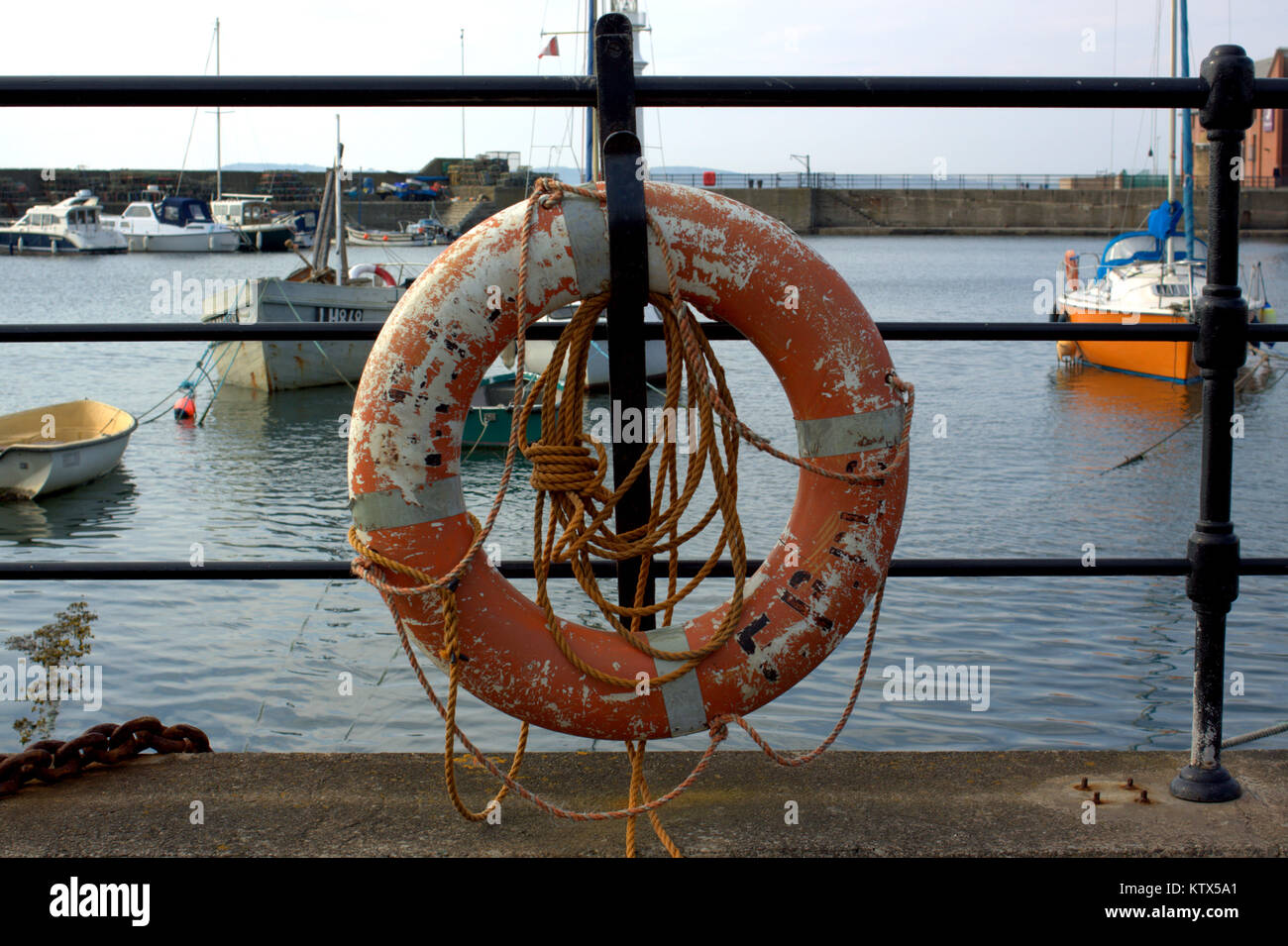 Newhaven, Western Harbour, Leith, Edinburgh, Vereinigtes Königreich alltägliche Szene Boote im Hafen Rettungsring Überstand in Vordergrund Stockfoto