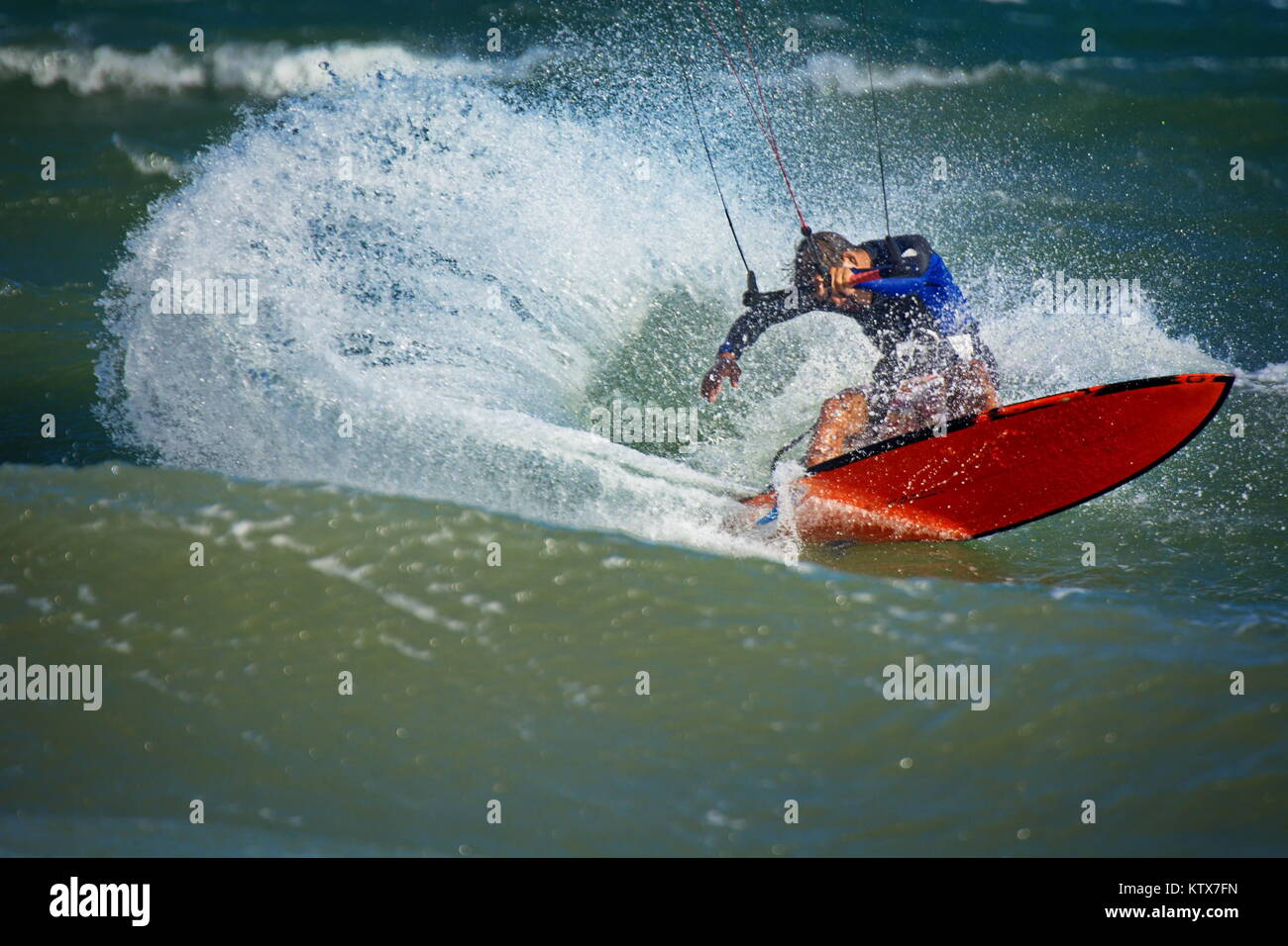 Surfer kitesurfen Wellen auf einem Surfbrett mit einem Big Splash Stockfoto