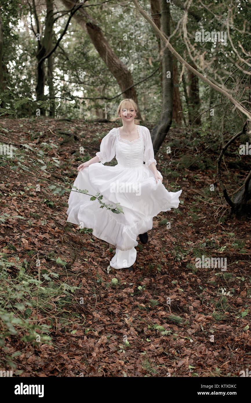 Schöne blonde Mädchen in einem weißen Kleid in voller Länge in der Landschaft Stockfoto