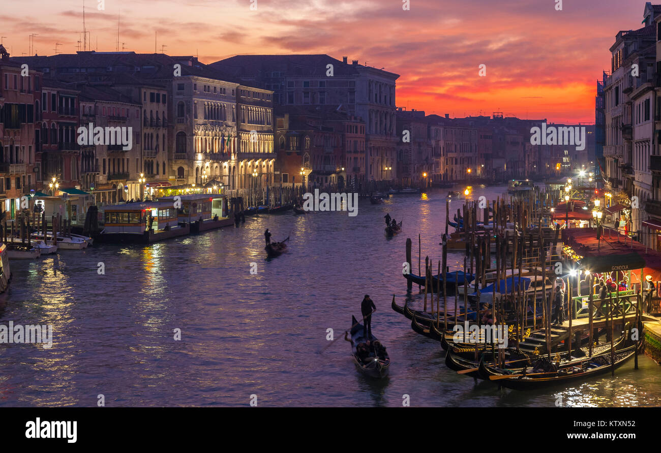Gondeln auf dem Canal Grande bei Sonnenuntergang von der Rialto Brücke, Venedig, Italien mit Licht im Winter Nebel, Dämmerung, Nacht Stockfoto