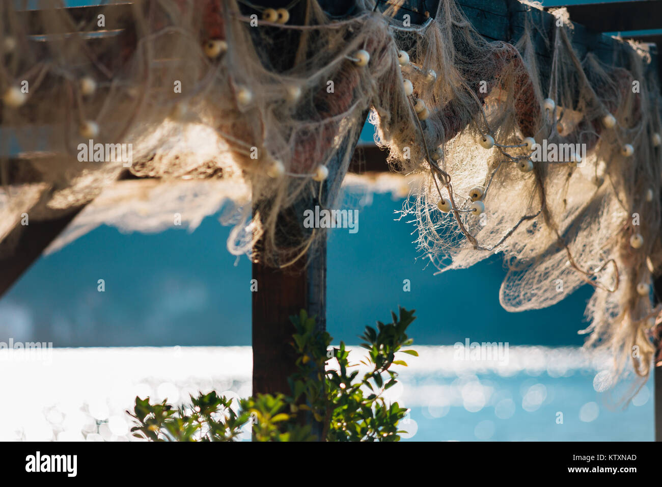 Alte Fischnetz Hängen auf Holz- bau an dem sonnigen Tag in der Nähe des Meeres. Stockfoto