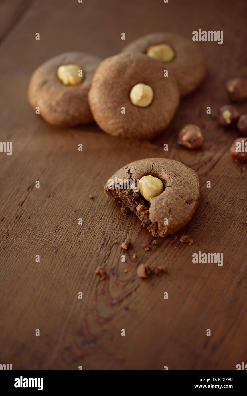 Künstlerische Foto von home-made Haselnuss butter Cookies auf braune Holztisch Hintergrund , zuckerfreie Lebensmittel Desserts noch Ife Stockfoto