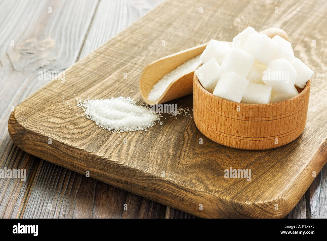 Holz- Schaufel und Schüssel mit Zucker auf Tisch, Nahaufnahme. Stockfoto