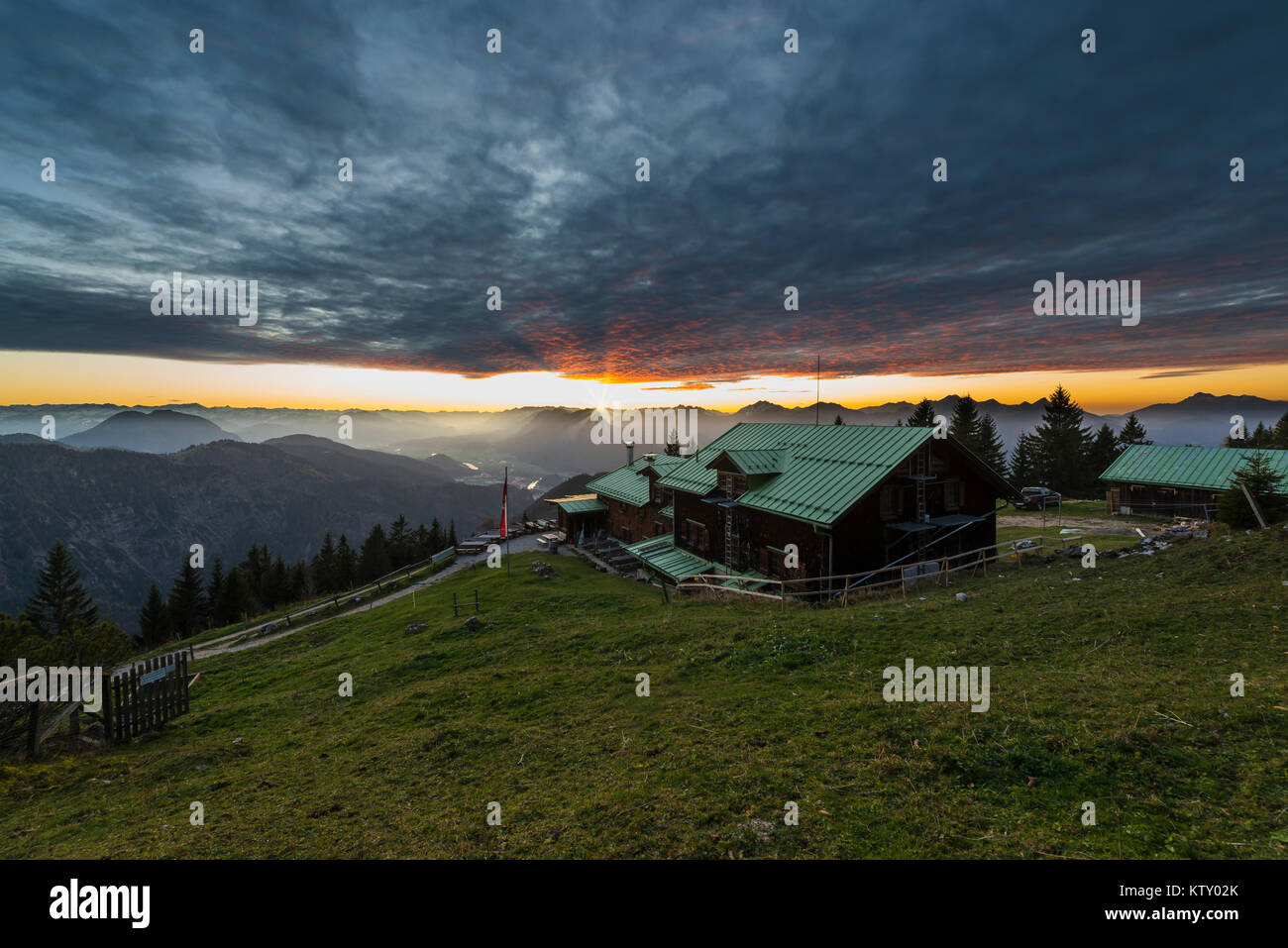 Sonnenuntergang und glühenden Wolken mit alpenpanorama an der Berghütte Vorderkaiserfeldenhütte in der Kaiser über dem Inntal, Tirol, Österreich Stockfoto