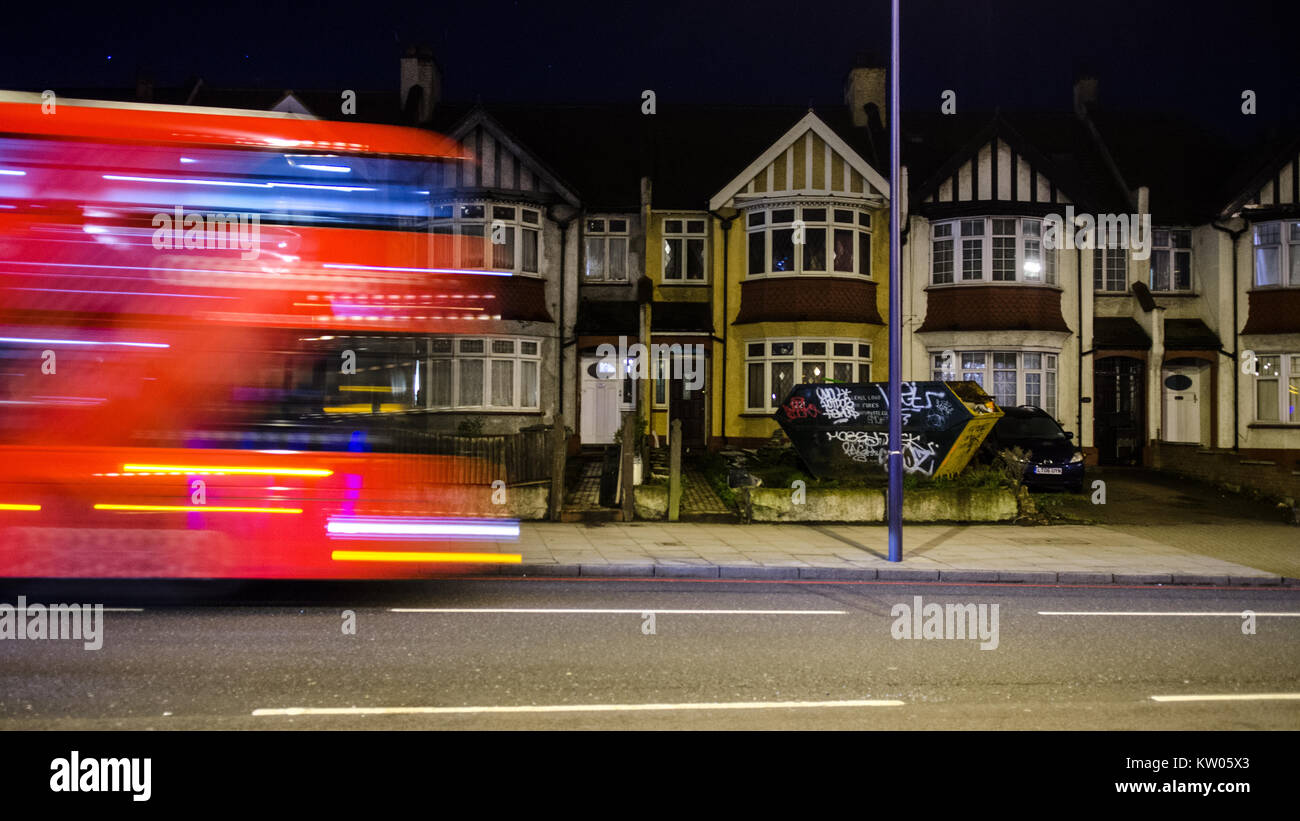 London, England, Großbritannien - 6. Januar 2015: der Verkehr rauscht entlang der geschäftigen New Cross Road im Süden Londons, letzten Zeilen von Reihenhäusern. Stockfoto