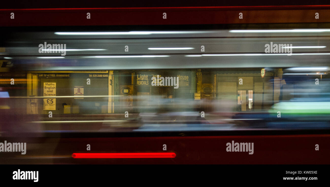 London, England, Großbritannien - 6. Januar 2015: der Verkehr rauscht entlang der geschäftigen New Cross Road im Süden Londons, letzten Zeilen des schäbigen Geschäfte. Stockfoto