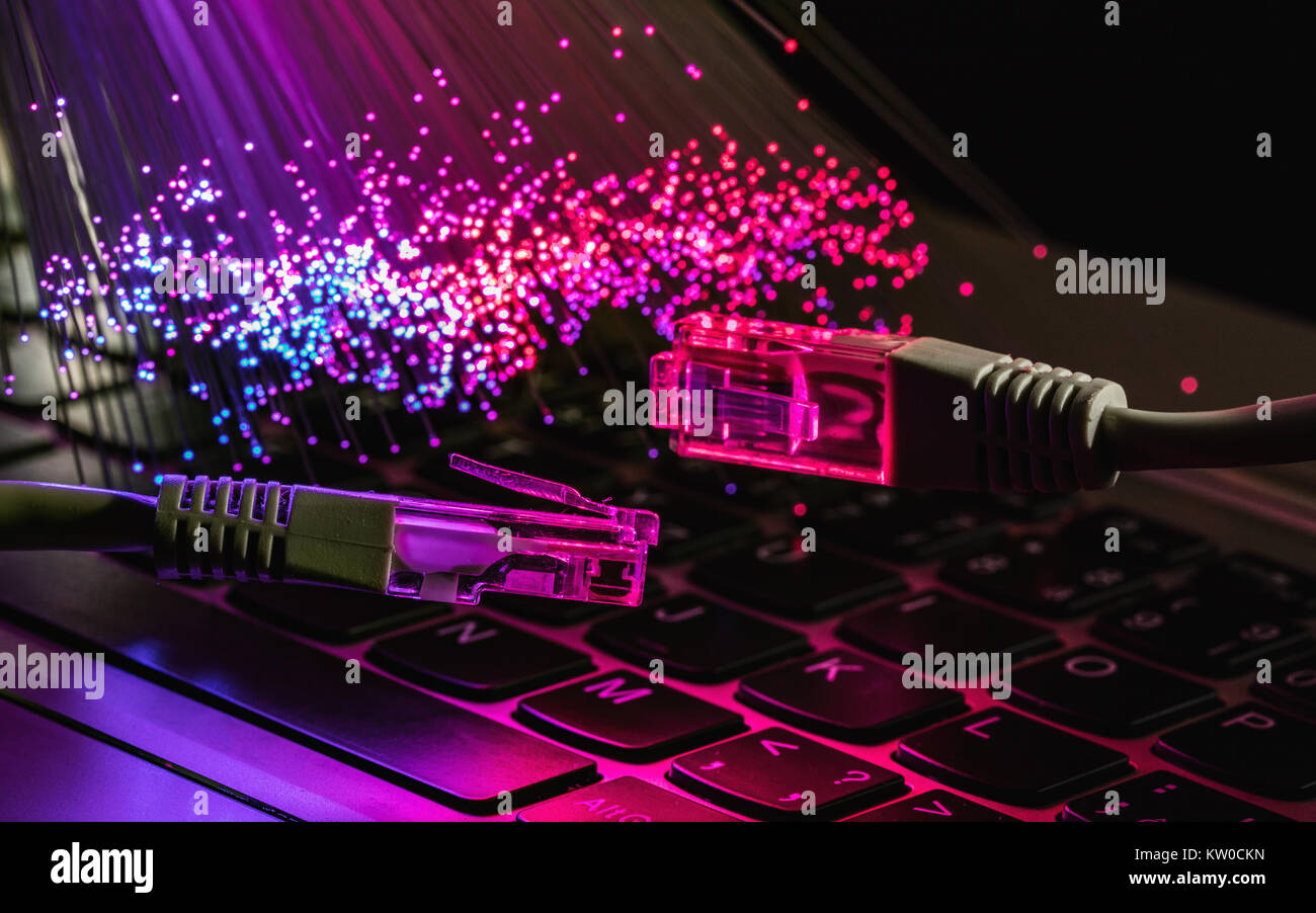 Netzwerkkabel closeup mit LWL-Hintergrund, Farbe LWL-Hintergrund mit notebookk, Fiberoptik Licht abstrakt Hintergrund Stockfoto