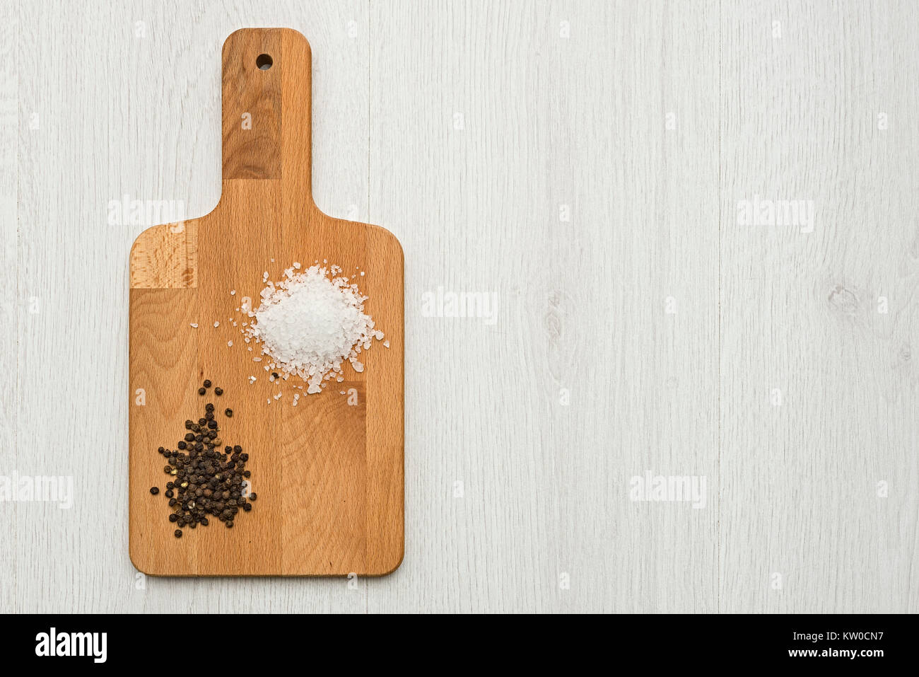 Holz Schneidebrett mit natürlichem Salz und schwarzer Pfeffer auf dem Tisch, mit kopieren. Stockfoto