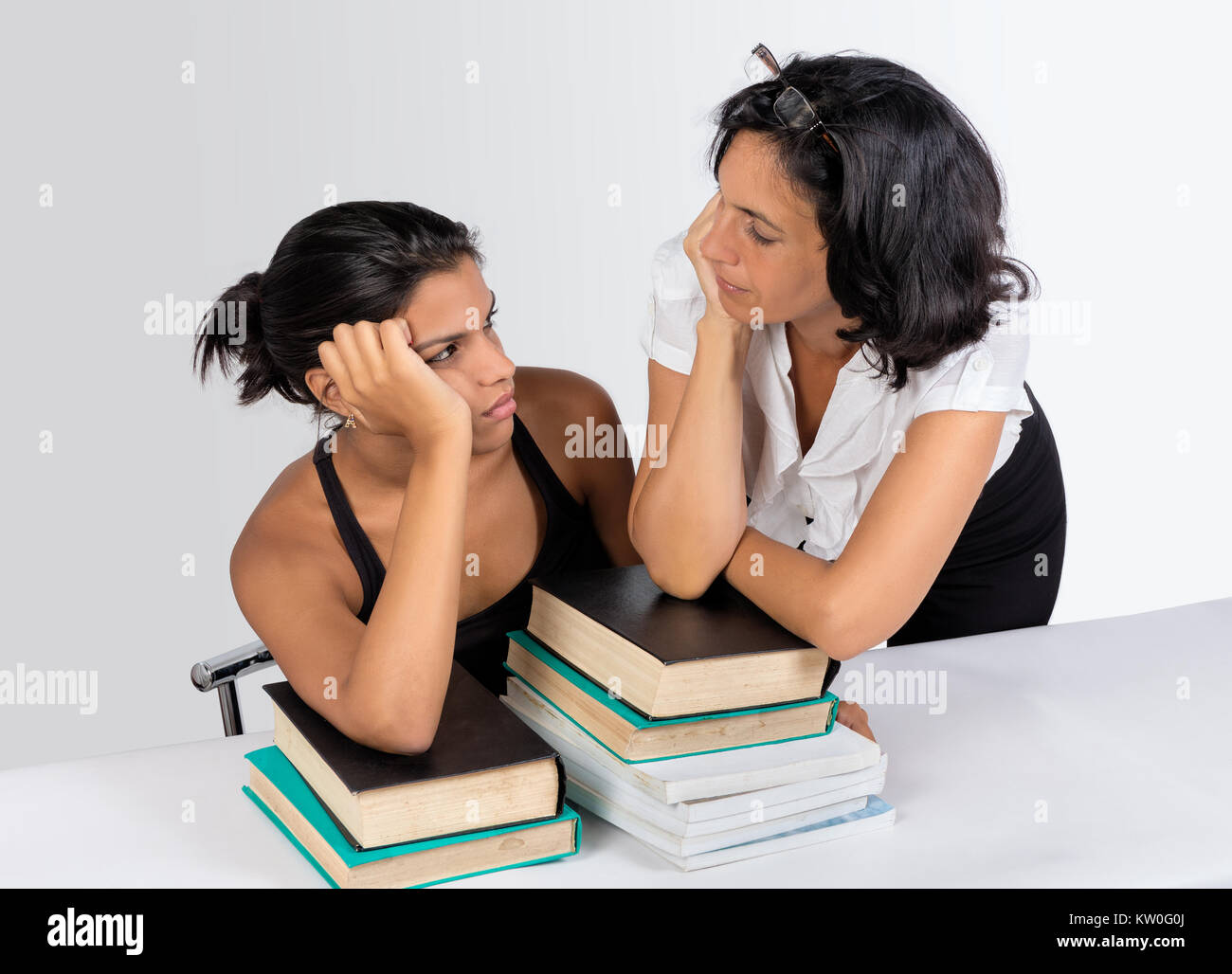 Ein Mädchen sitzen und eine womand Stand mit Büchern zu suchen Stockfoto