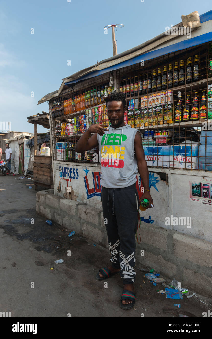 Junger Mann posiert vor einem Geschäft, Jamestown Fischerdorf, Jamestown, Accra, Ghana Stockfoto