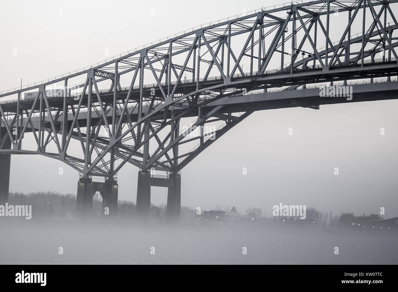 Die internationale Blue Water Bridge in dichtem Nebel mit Eisenbahnschienen im Vordergrund. Das blaue Wasser Brücken verbindet der USA und in Ontario, Kanada. Stockfoto