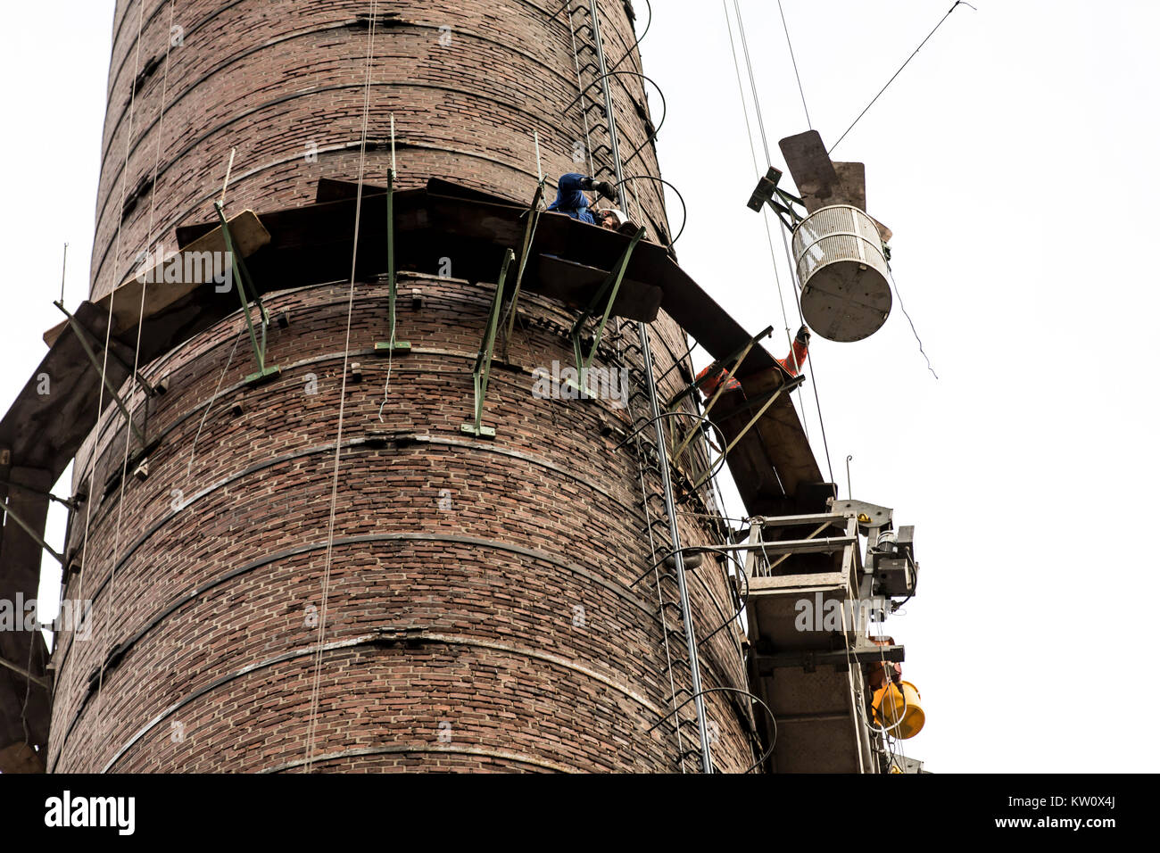 Gerüstbauer bei der Arbeit, eine große Gerüste, Arbeiten in großer Höhe, industrielle Schornstein reparieren. Stockfoto